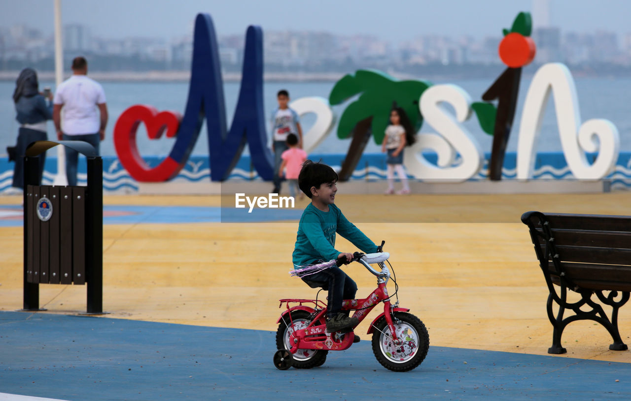 Side view of happy boy riding bicycles in park