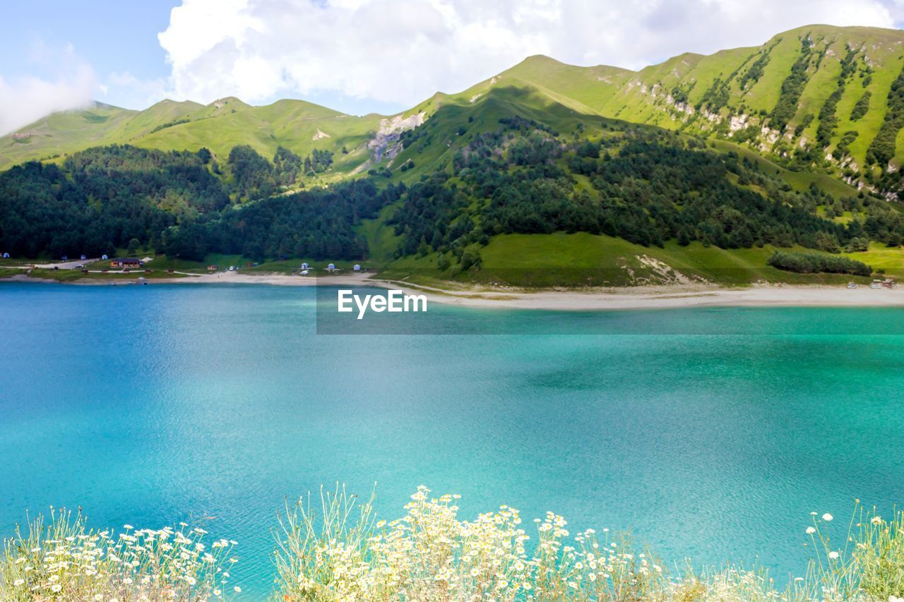 SCENIC VIEW OF LAKE AMIDST MOUNTAINS AGAINST SKY