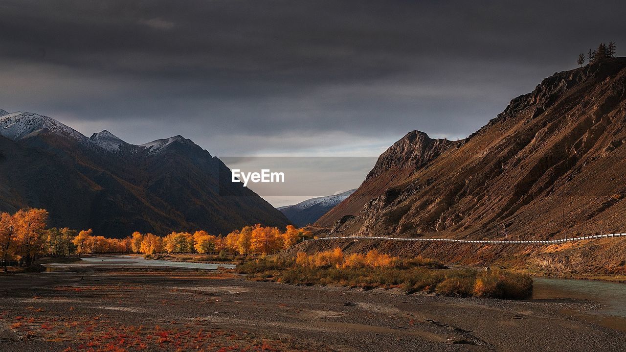 Road by mountain against sky during autumn