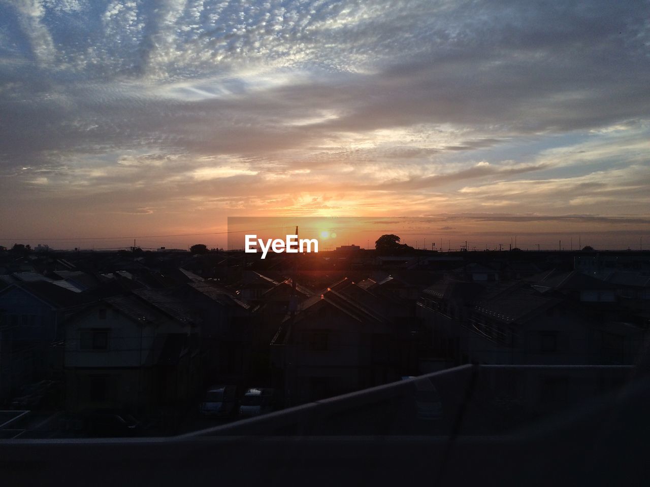 Residential district against cloudy sky at sunset