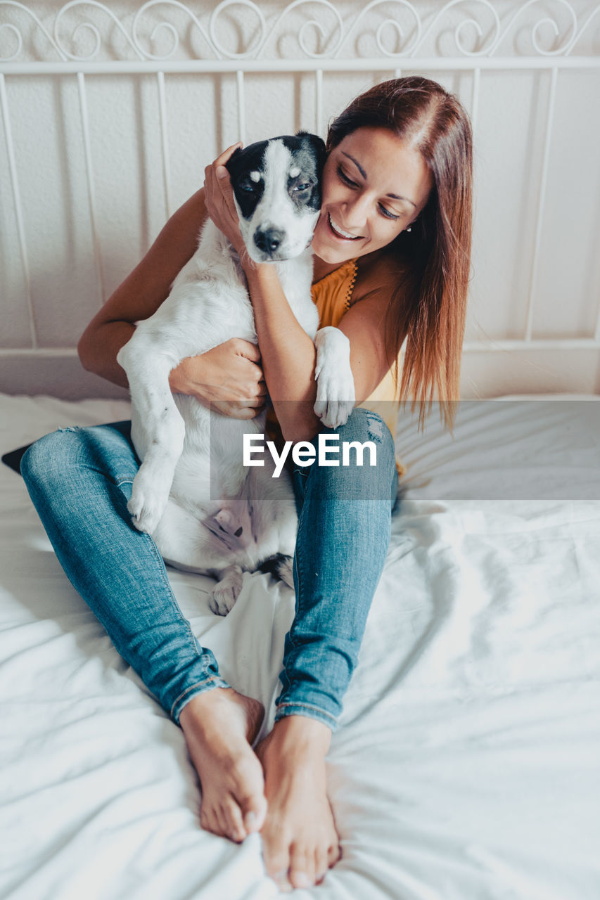 HAPPY WOMAN WITH DOG AT HOME