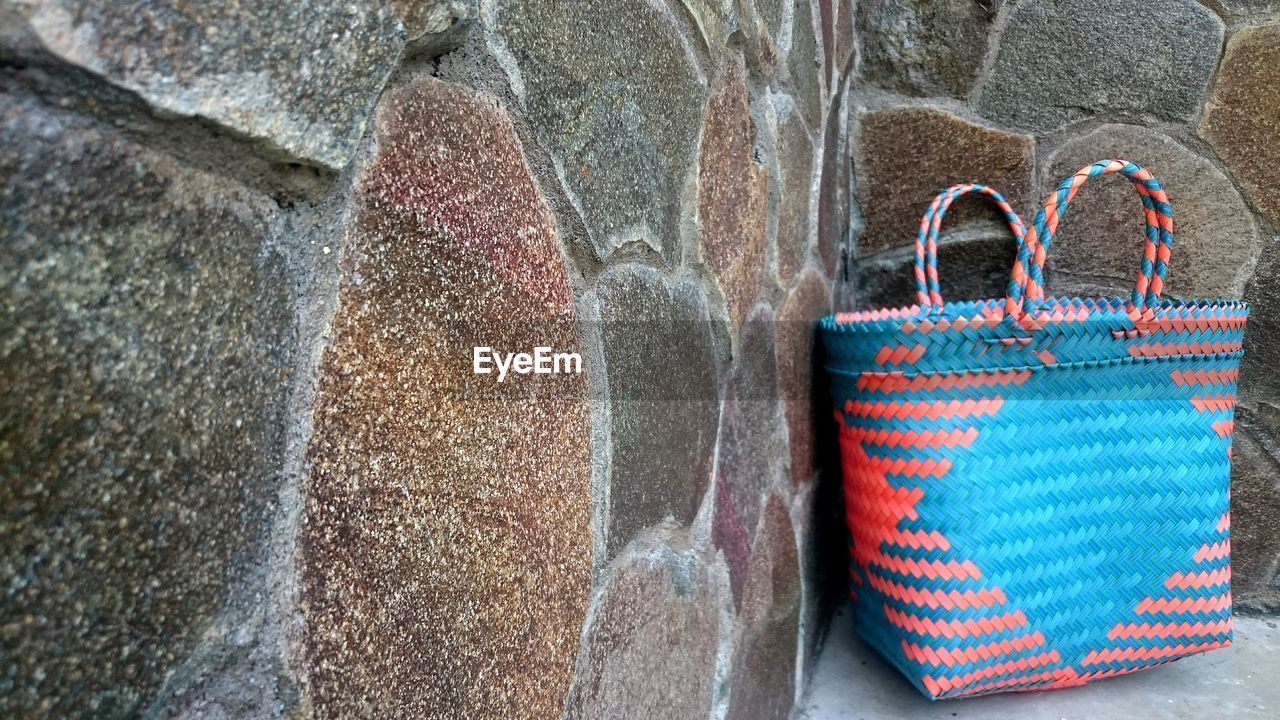 CLOSE-UP OF MULTI COLORED UMBRELLAS HANGING ON ROCK