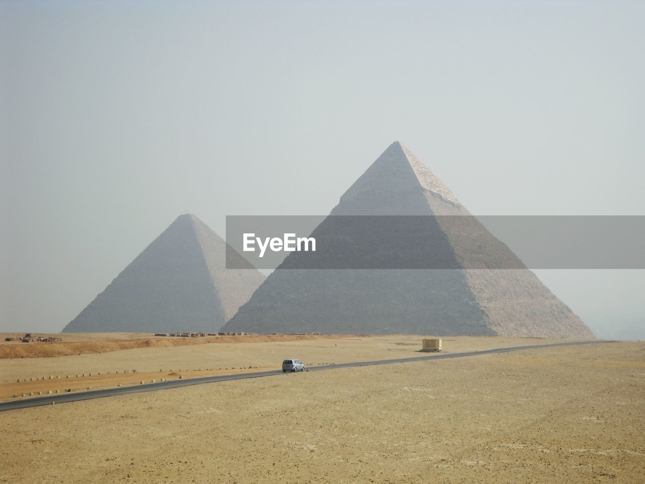 Great pyramid of giza on field against sky