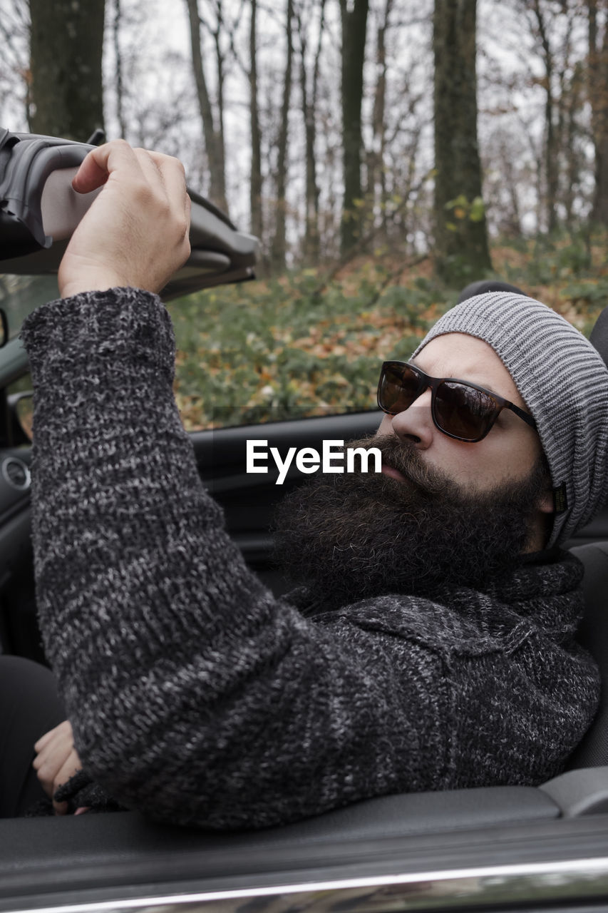 Portrait of man wearing knit hat sitting in car