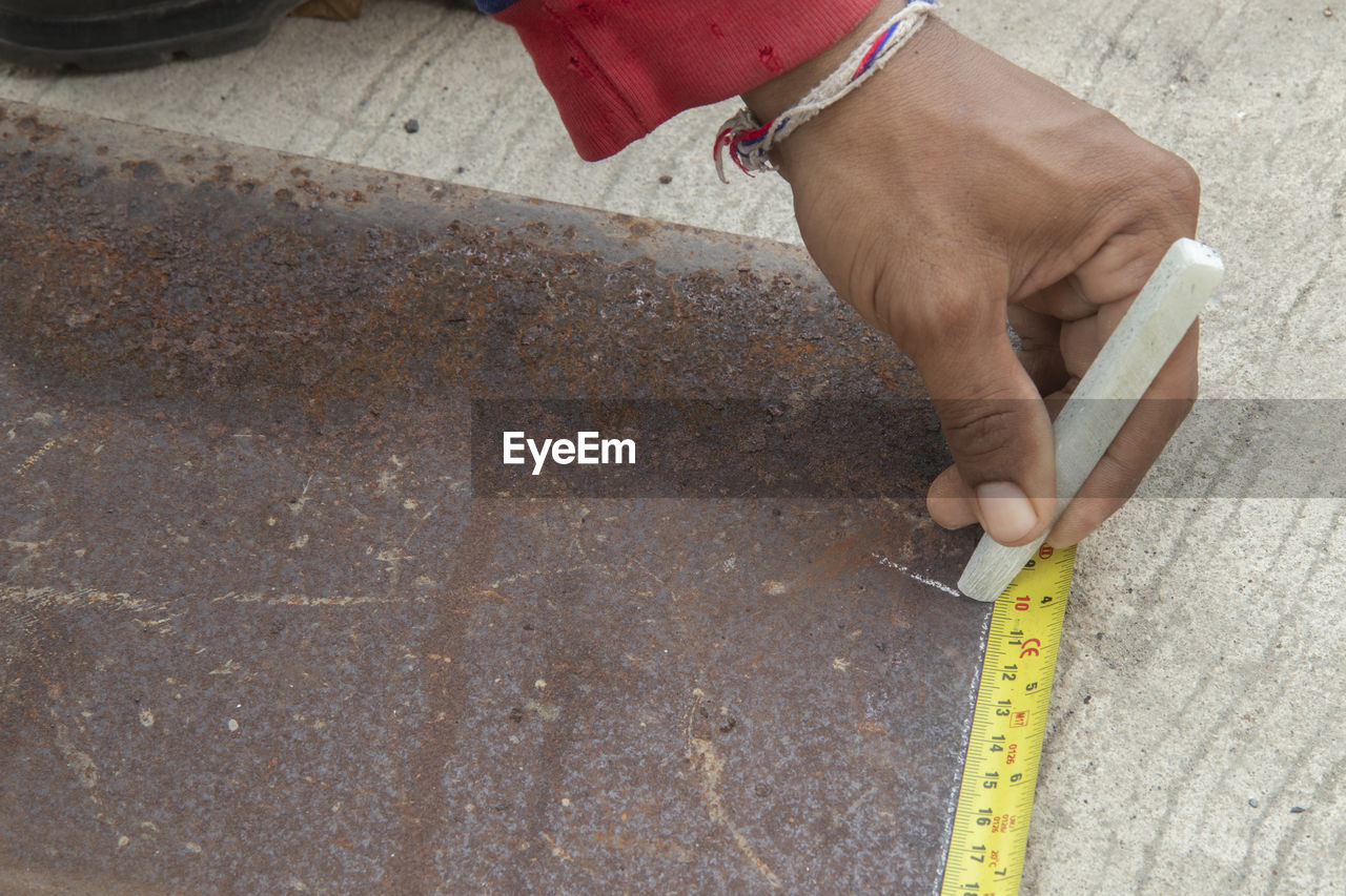 HIGH ANGLE VIEW OF PERSON WORKING ON STREET