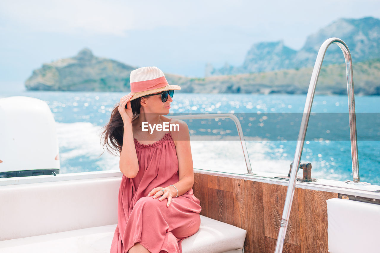 Woman looking away while sitting on boat