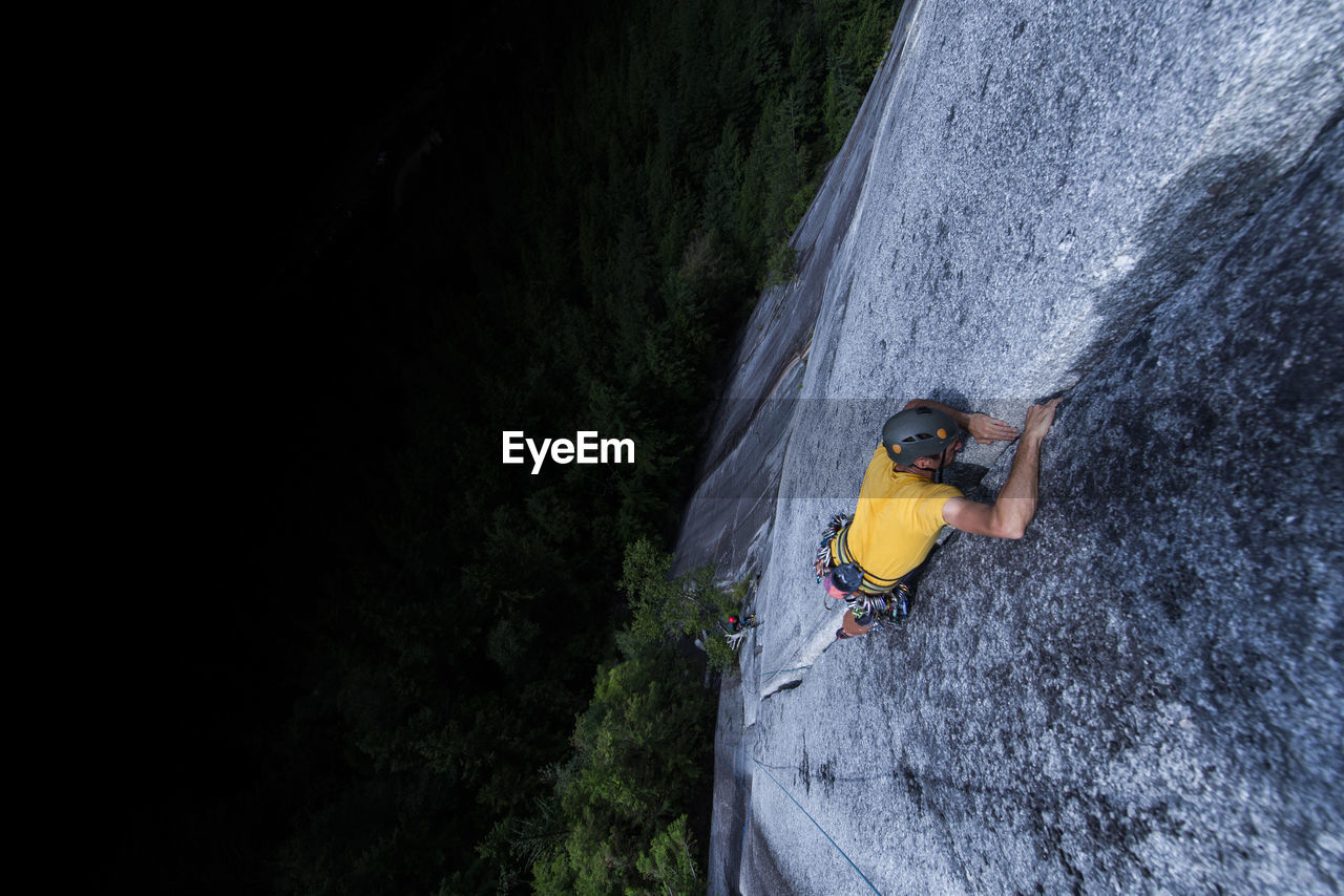 Man lead climbing granite crack very high and exposed squamish chief