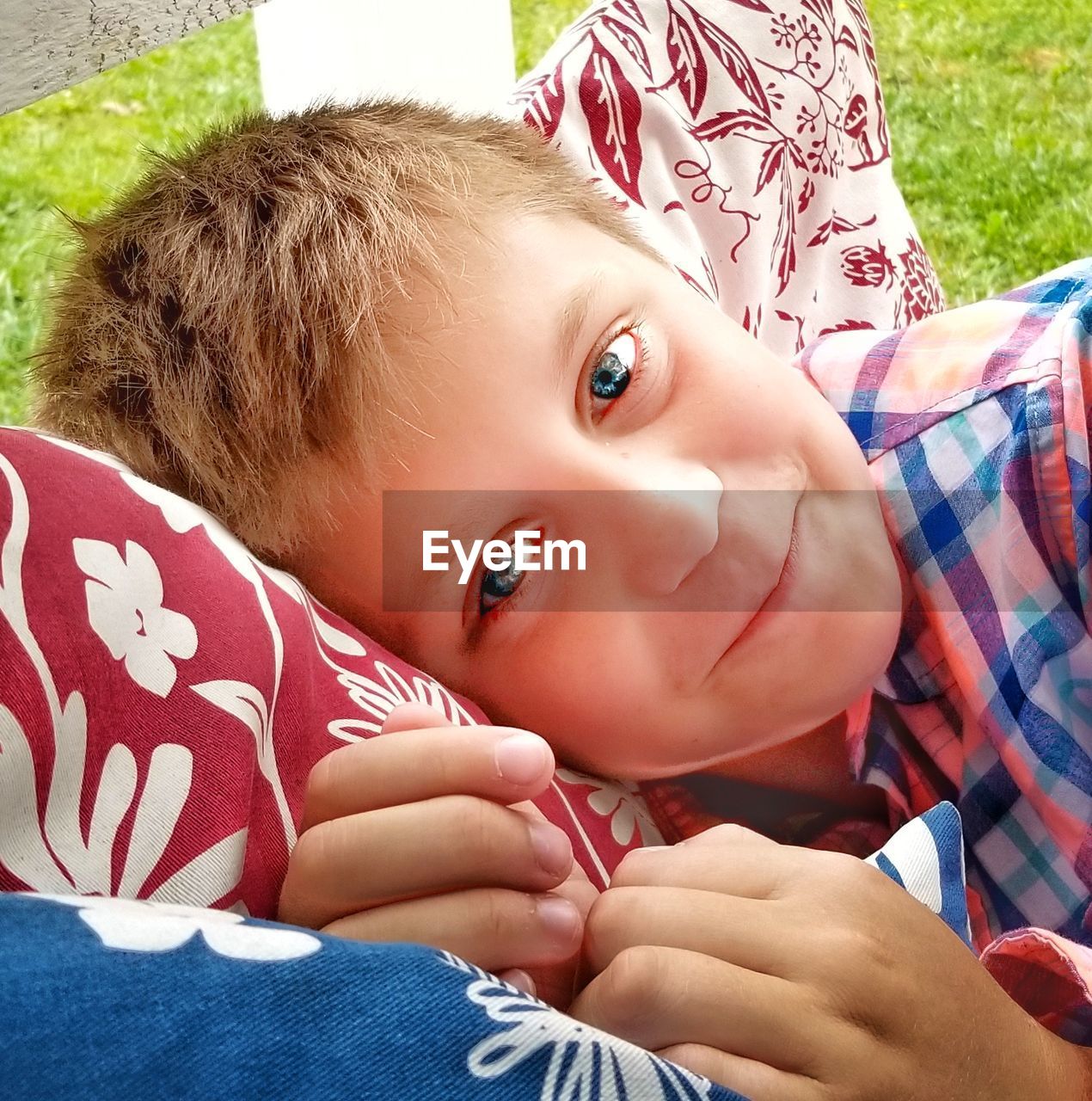 Portrait of cute boy lying down on cushion