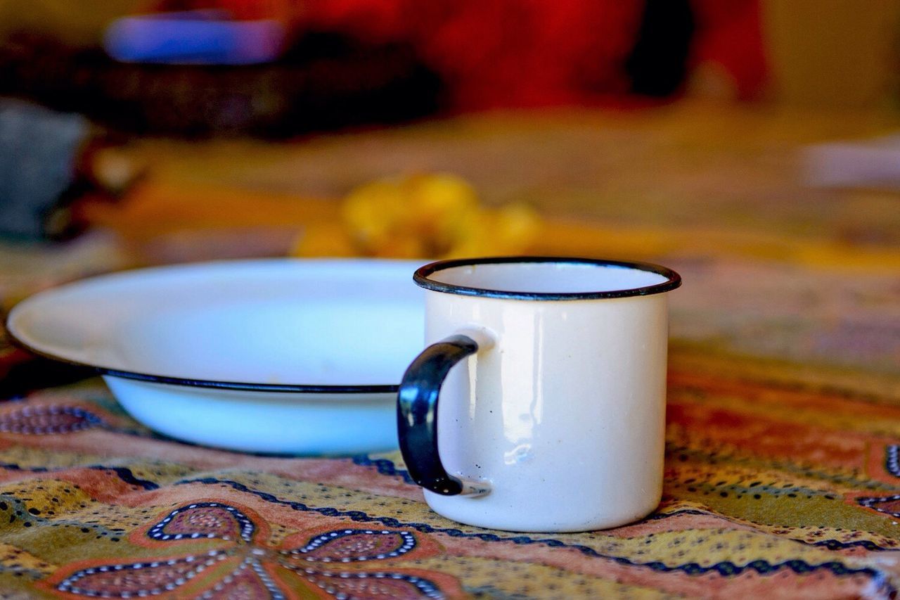 Close-up of white cup and plate on table