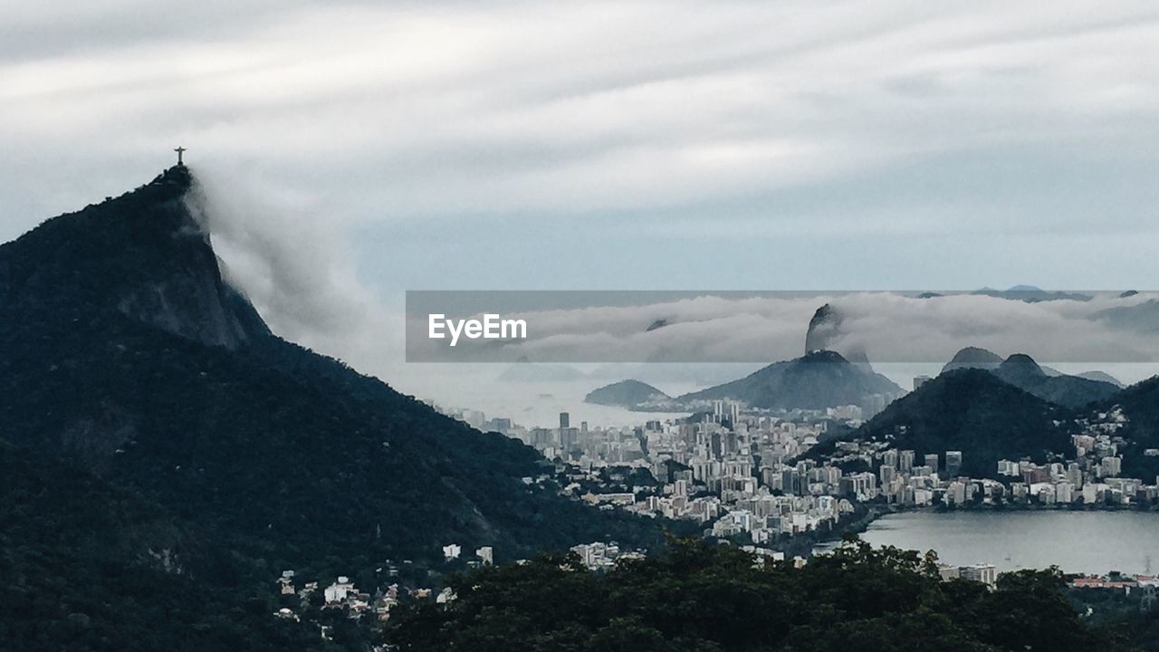 SCENIC VIEW OF CITYSCAPE AGAINST CLOUDY SKY