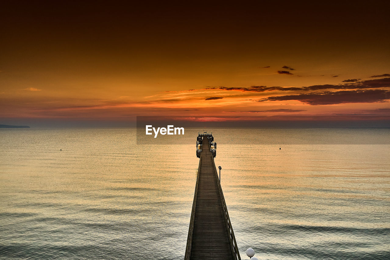 SILHOUETTE PIER OVER SEA AGAINST SKY AT SUNSET