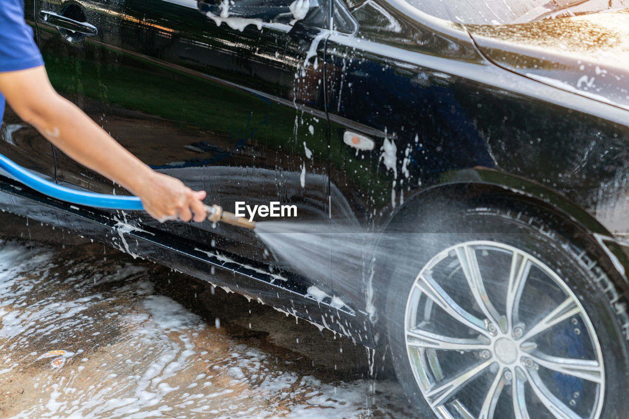 The washing process on a self service car wash high pressor spray water on wheel.