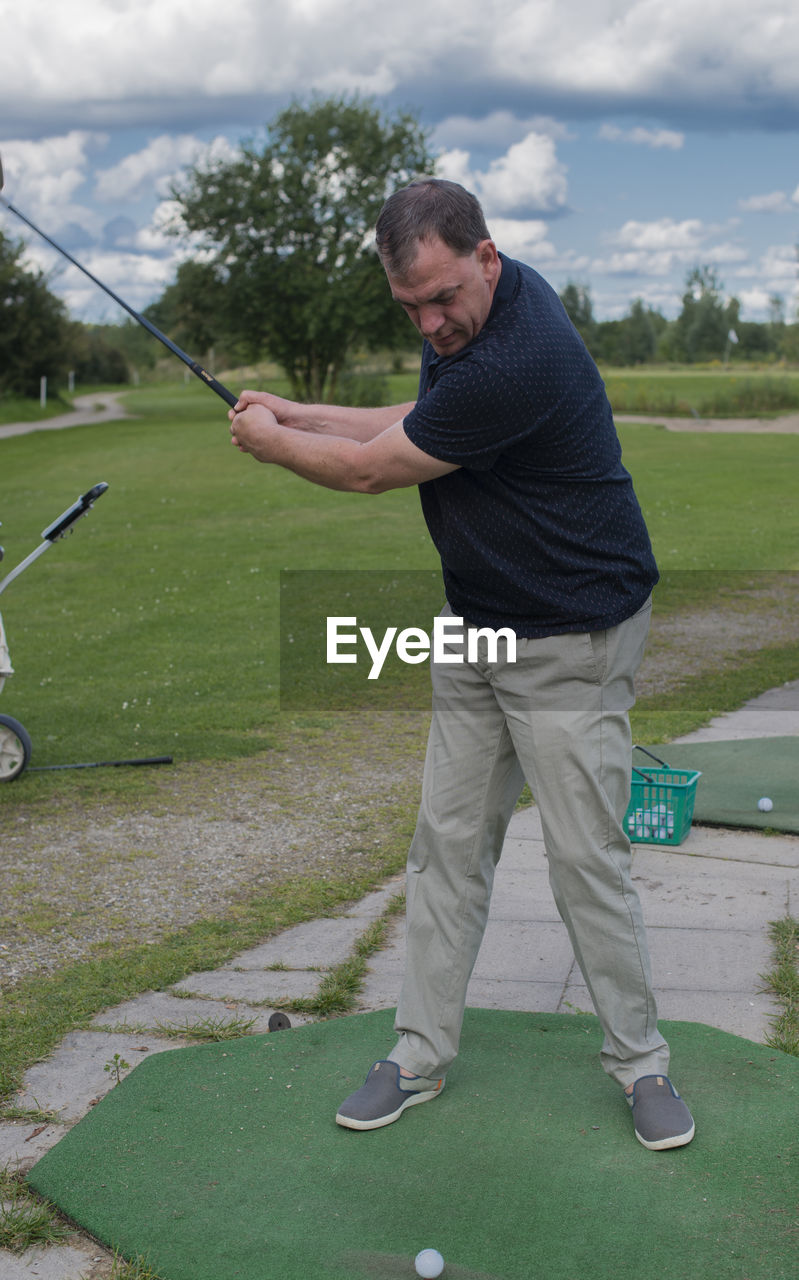 Full length of man playing golf on field