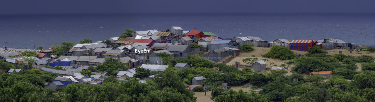 High angle view of townscape by sea against sky