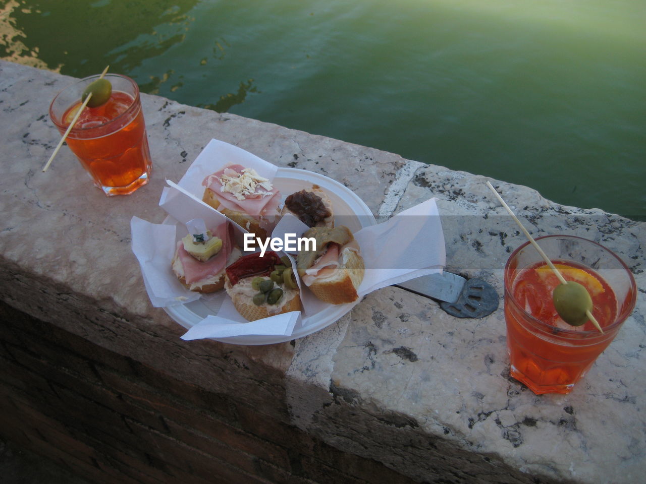 High angle view of food on retaining wall by lake