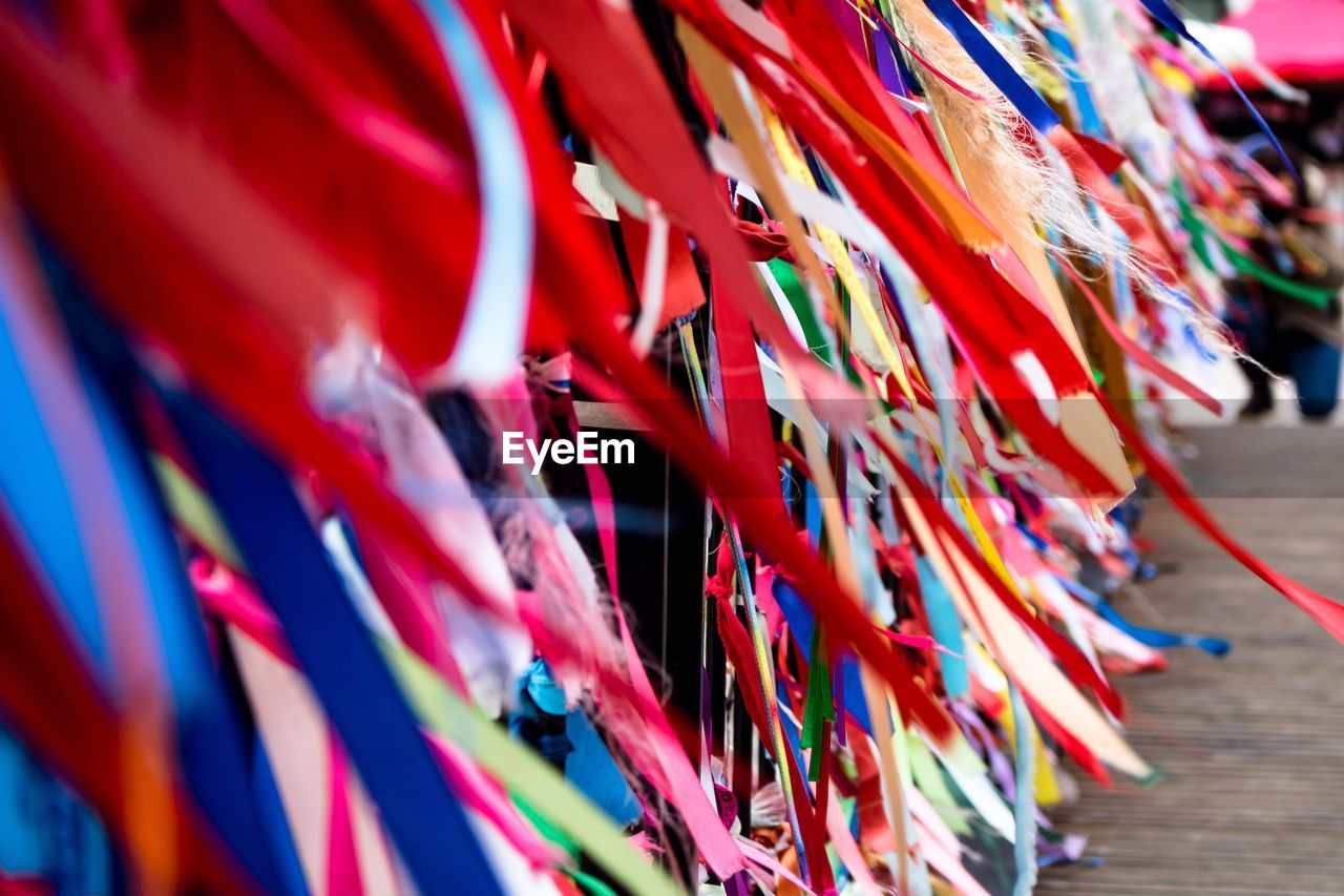 CLOSE-UP OF MULTI COLORED DECORATIONS HANGING ON CLOTHESLINE