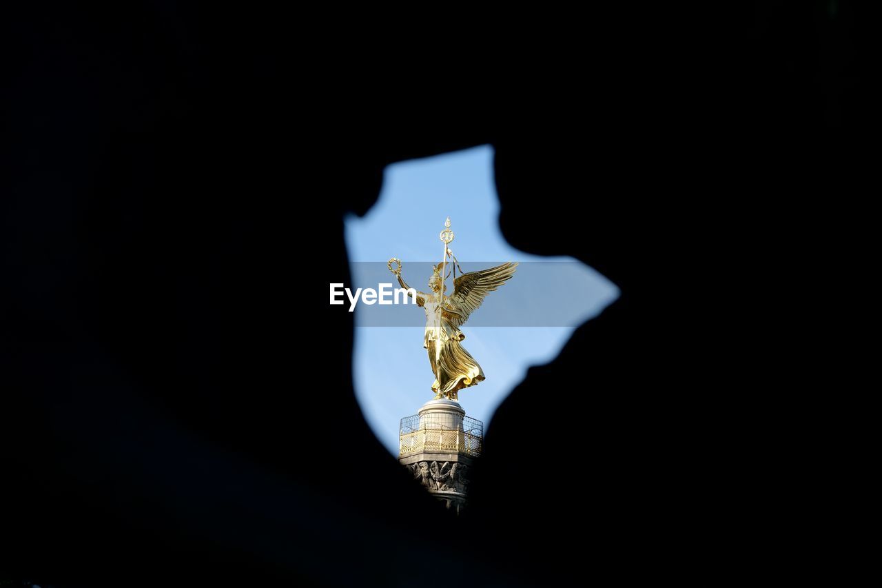 Low angle view of angel statue against black background