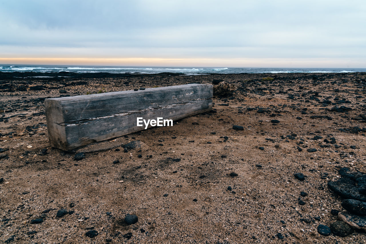 land, beach, shore, sky, sea, coast, water, nature, sand, ocean, rock, scenics - nature, tranquility, cloud, horizon, tranquil scene, wave, horizon over water, beauty in nature, no people, natural environment, day, body of water, outdoors, abandoned, non-urban scene, wood, environment, idyllic