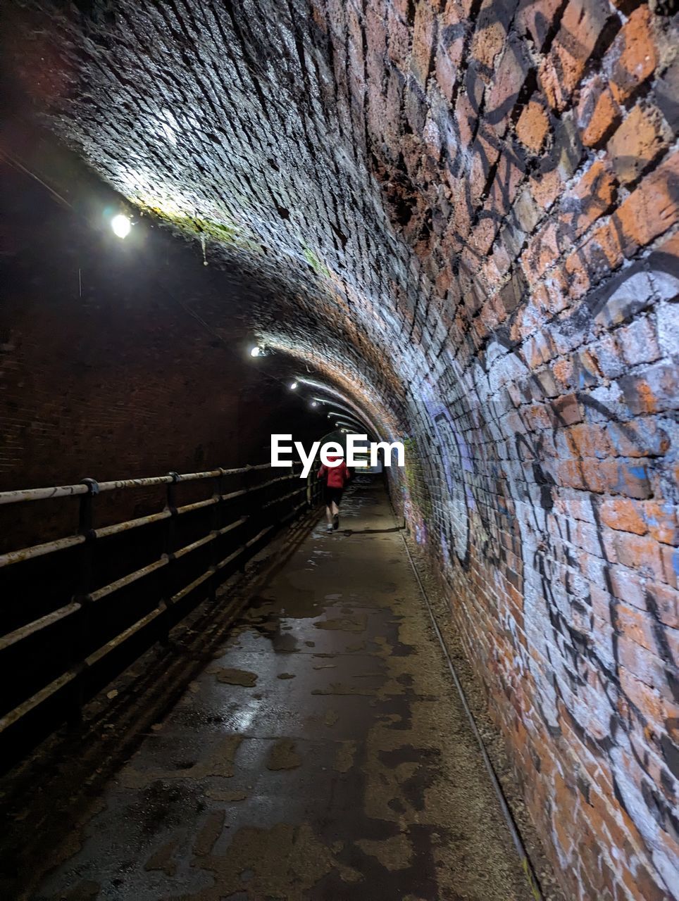 tunnel, infrastructure, architecture, transportation, illuminated, built structure, the way forward, city, nature, outdoors, lighting equipment, mode of transportation, men, footpath, street, cave, night, one person, water, diminishing perspective, full length, motion, reflection, arch, wet