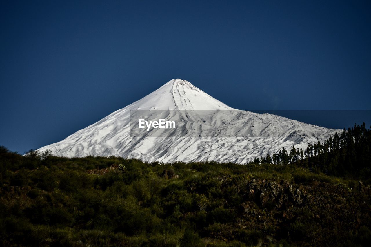 Scenic snowcapped mountain against blue sky