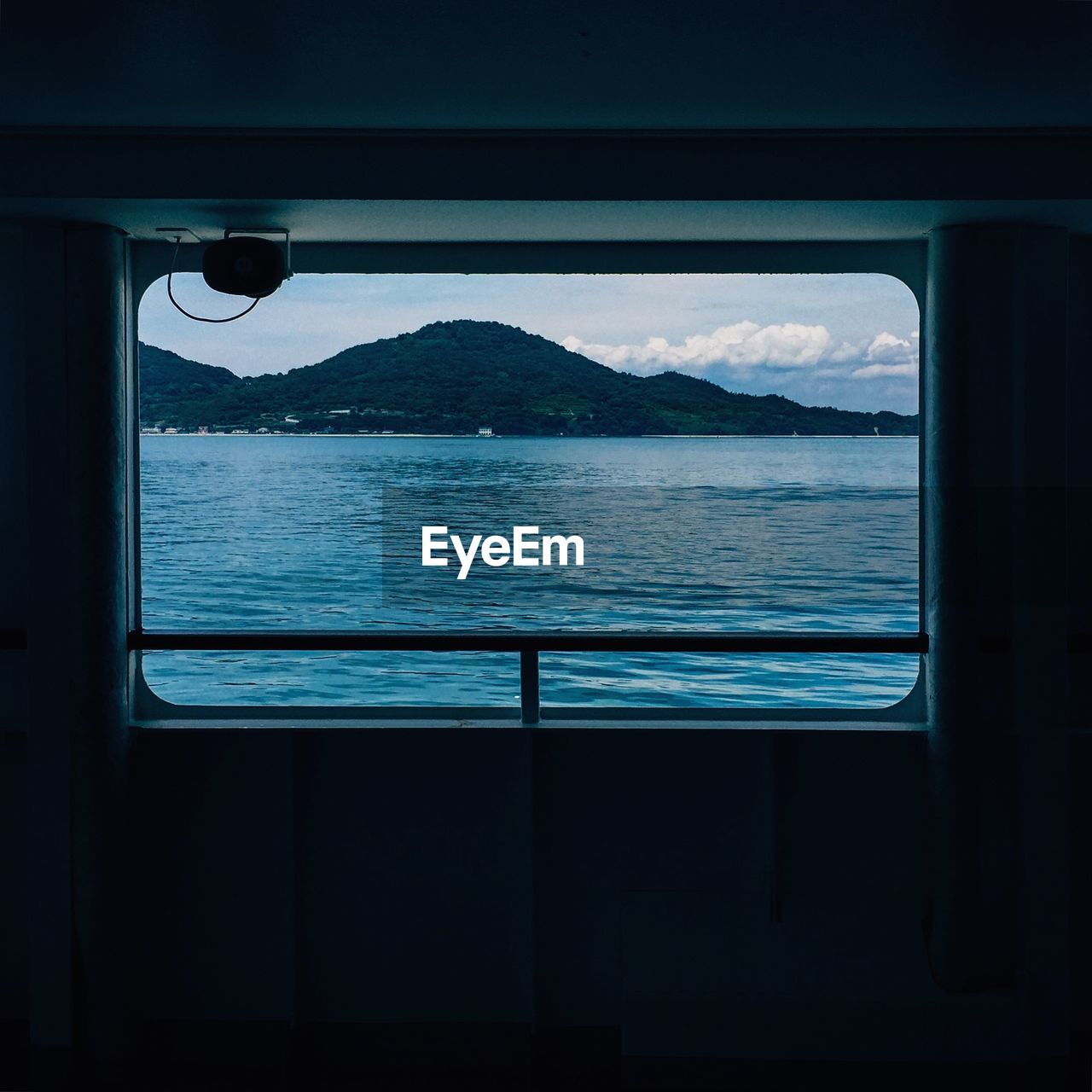 Sea and mountain seen through window of ship