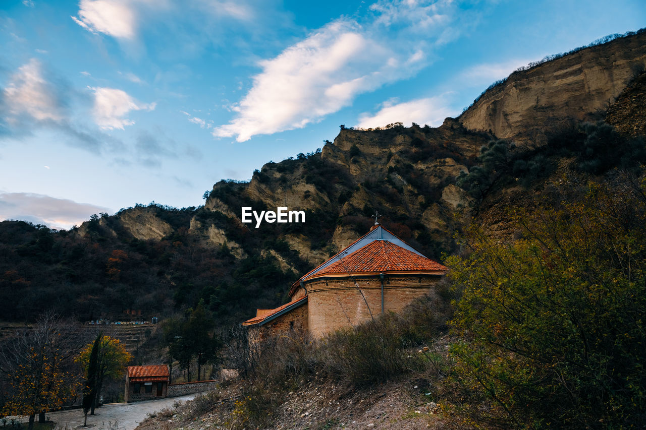 Traditional building by mountains against sky