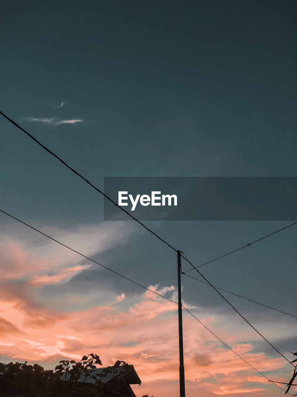 Low angle view of silhouette electricity pylon against sky during sunset