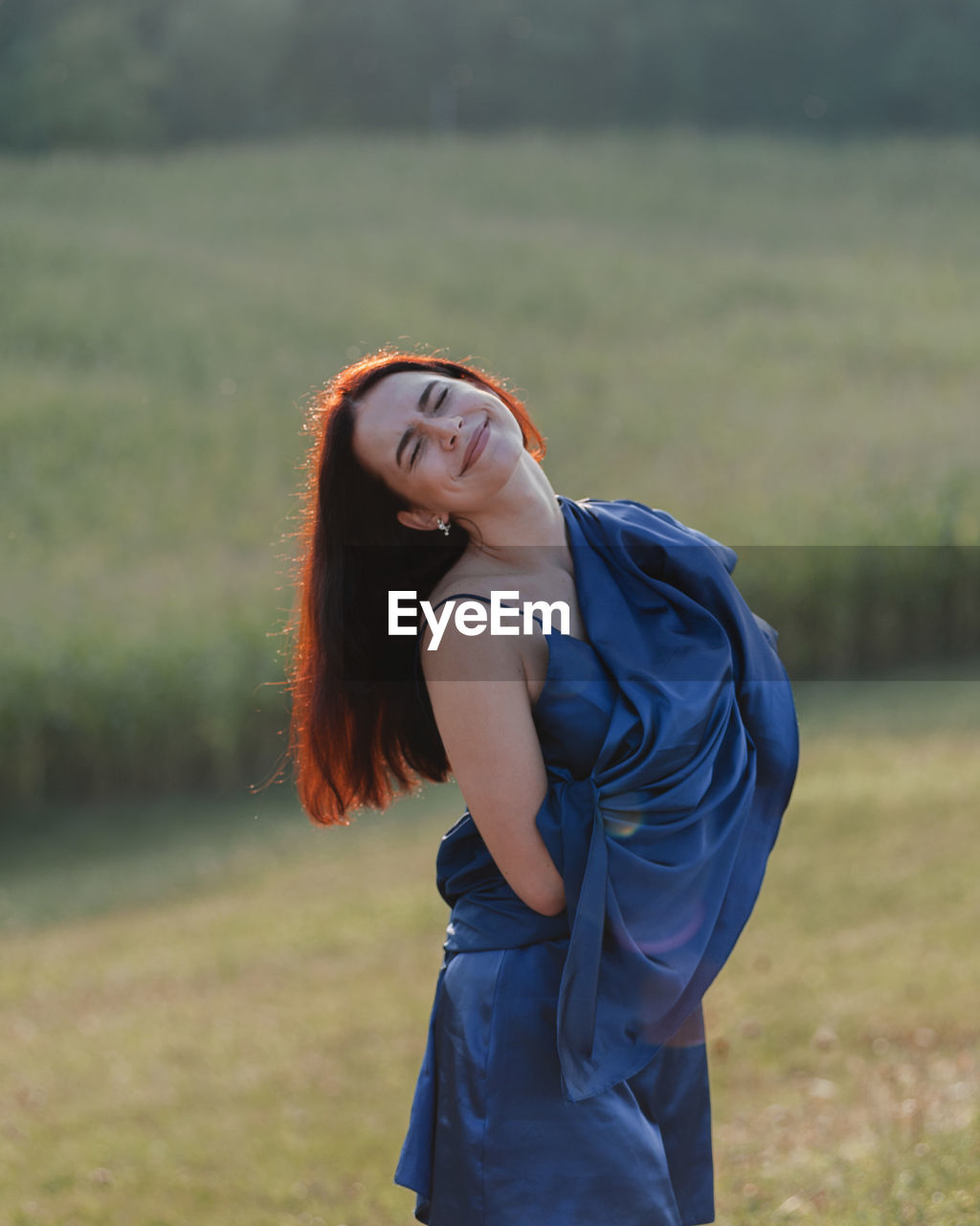 Portrait of young woman standing on field