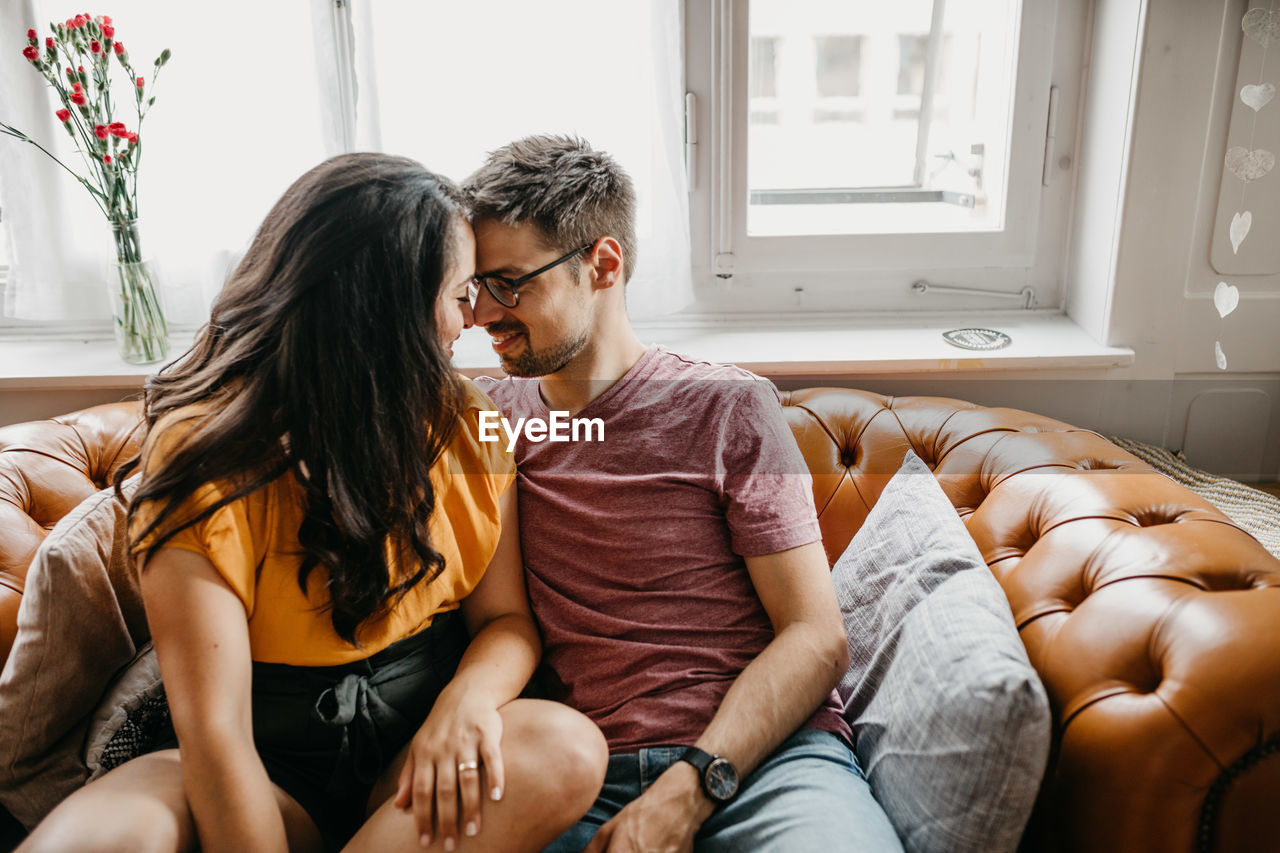 Romantic couple sitting on sofa at home