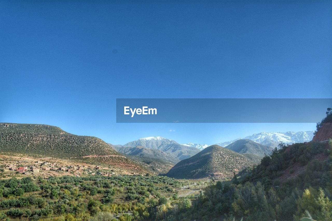 Scenic view of mountains against clear blue sky