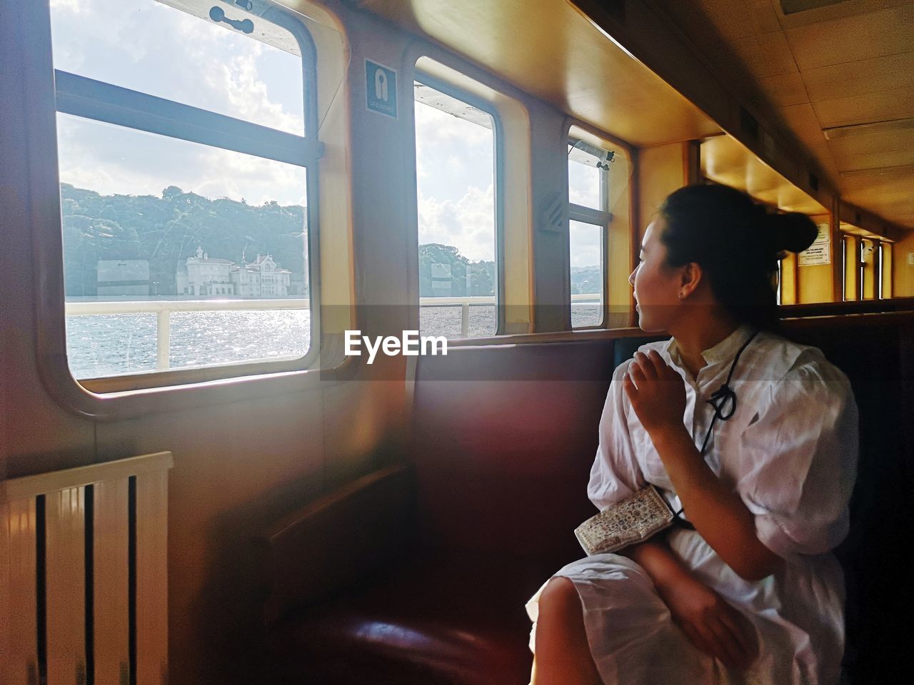 Woman looking through steamboat  window
