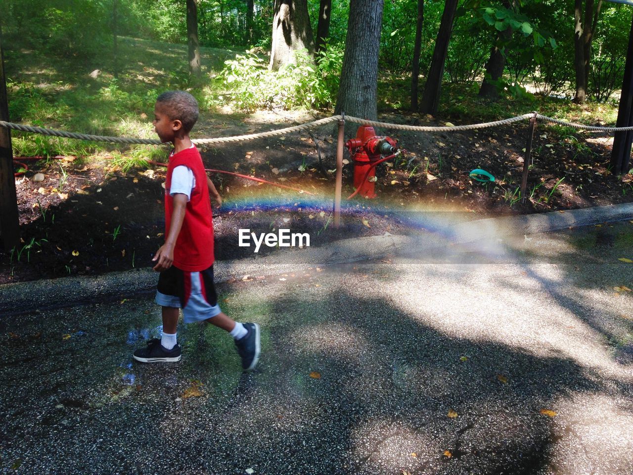 FULL LENGTH OF BOY PLAYING ON WATER