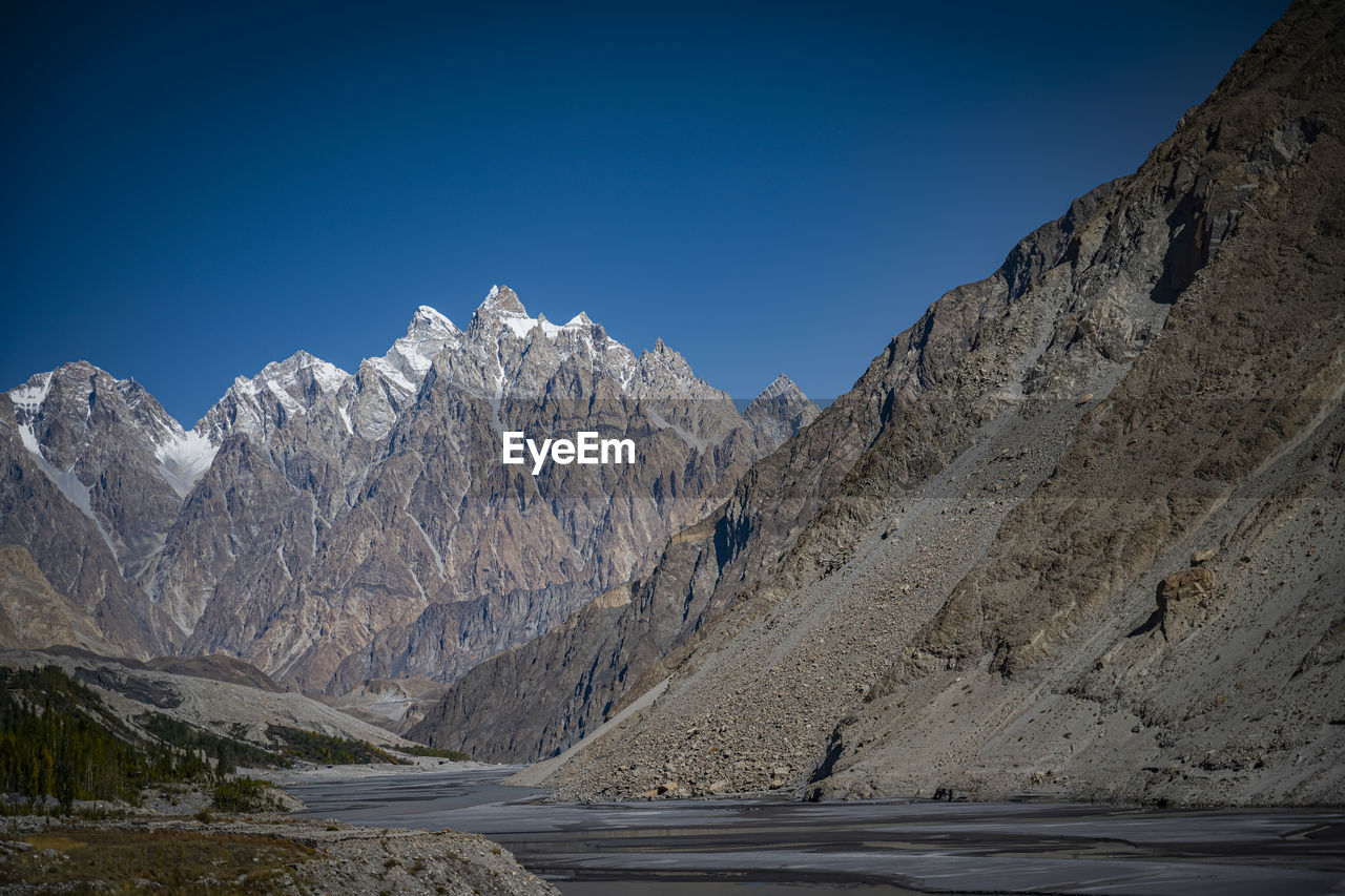 Scenic view of snowcapped mountains against clear blue sky