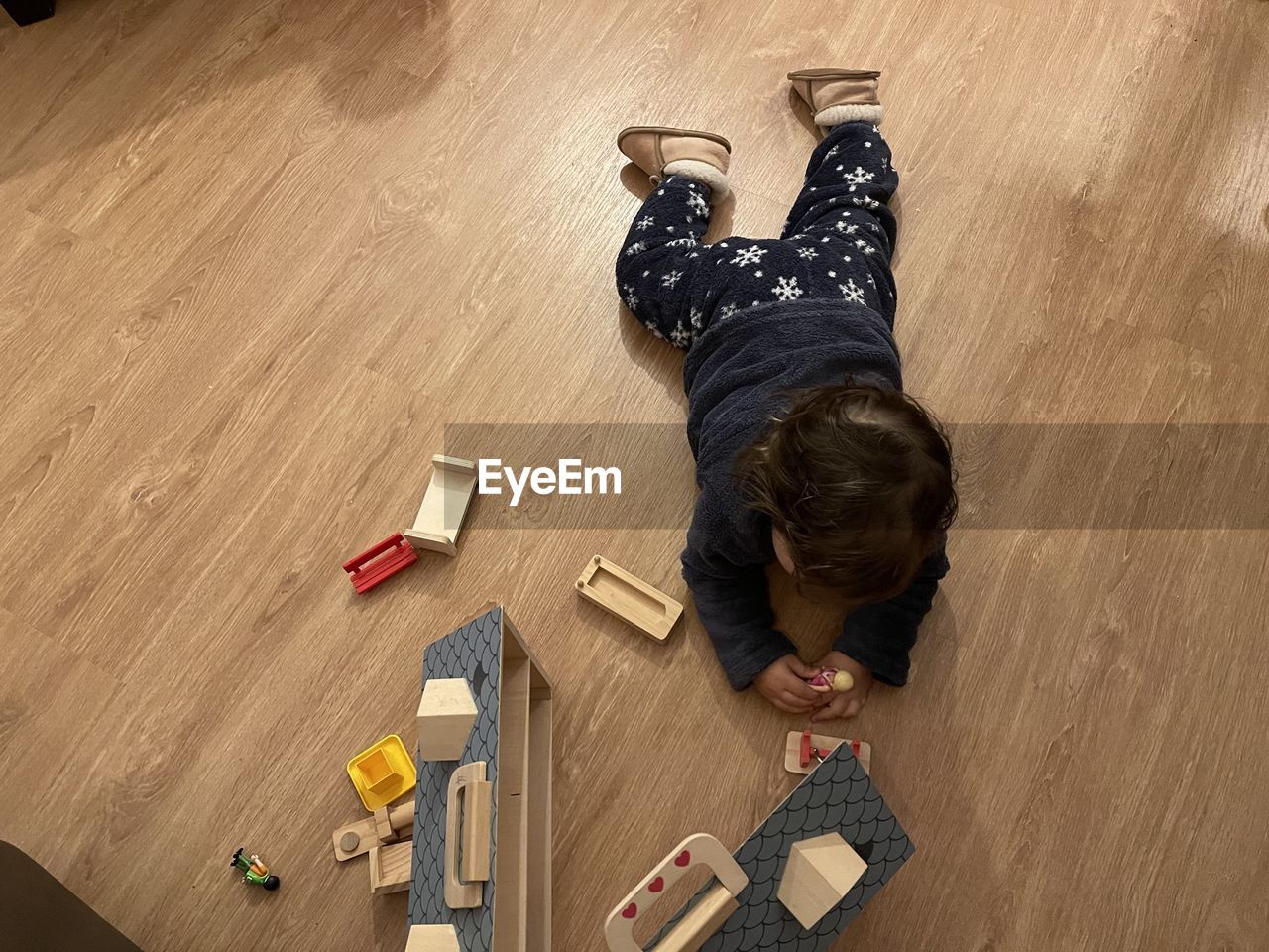 HIGH ANGLE VIEW OF BOY LYING ON FLOOR AT HOME