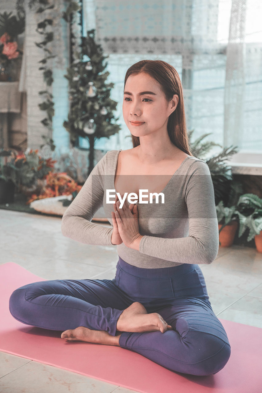 Woman meditating while sitting at home