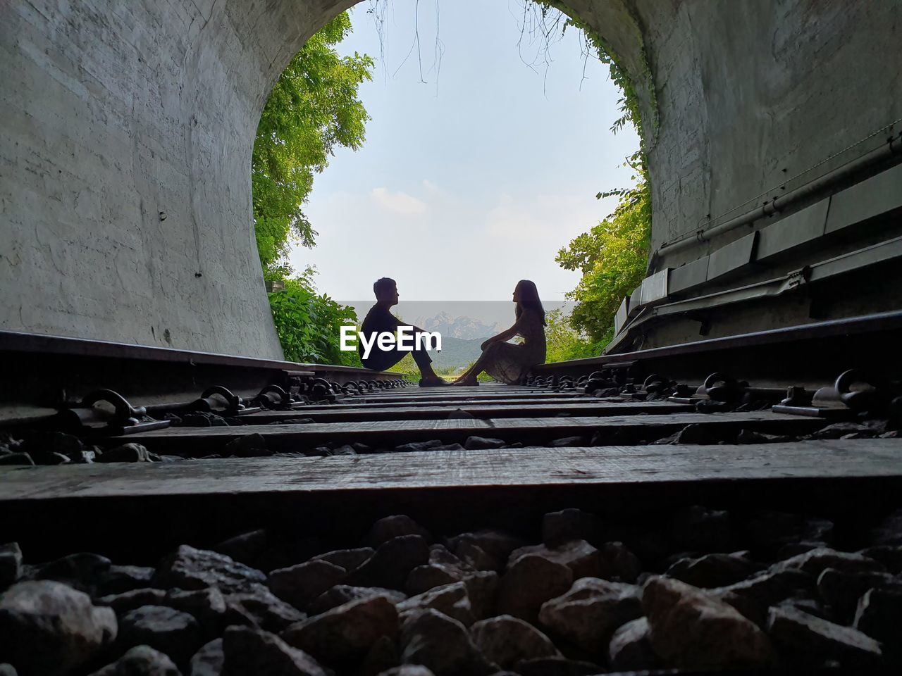 PEOPLE ON RAILROAD TRACKS AGAINST SKY