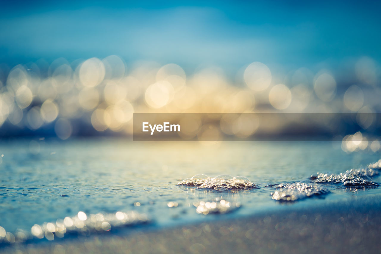 Beautiful small waves on the sea sand at the beach. sunset scenery of a baltic sea beach.