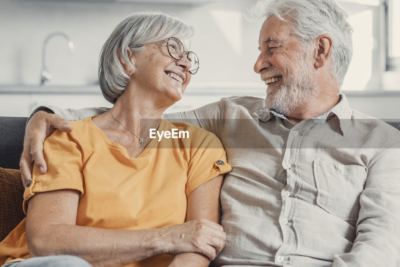 portrait of senior couple sitting on sofa at home