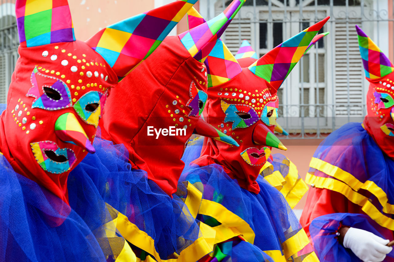 celebration, carnival, event, multi colored, tradition, group of people, festival, day, disguise, costume, flag, outdoors, architecture, parade, mask, city, representation, clothing, chinese new year, traditional clothing, mask - disguise, arts culture and entertainment, traditional festival