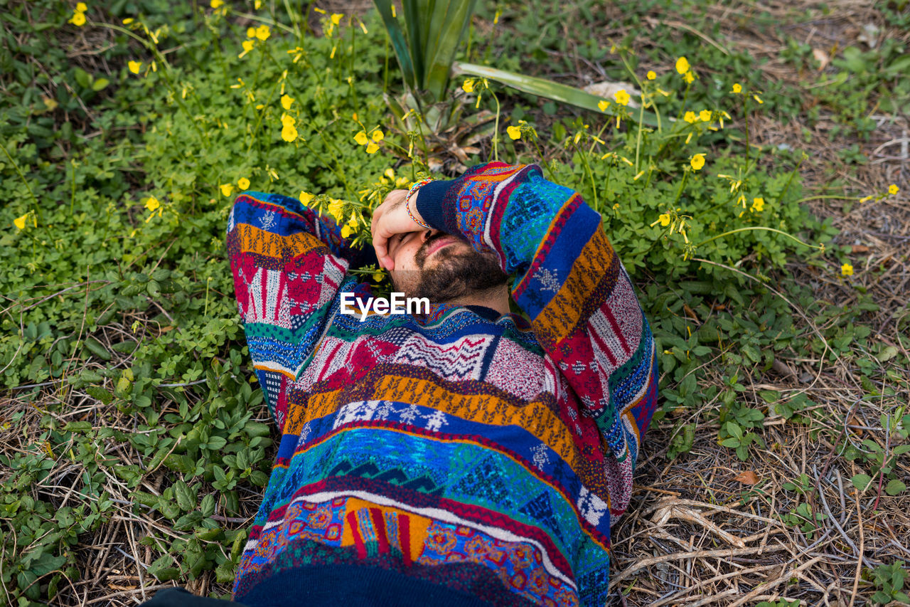 Moroccan man laying on the ground with his hand over his face