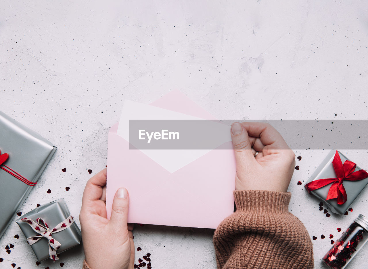 Female hands hold love letter empty message in open envelope, valentine's day greeting card