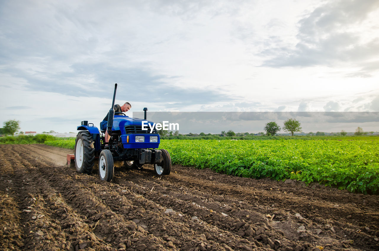 Farmer with tractor working in the field. milling soil, crushing and loosening ground 