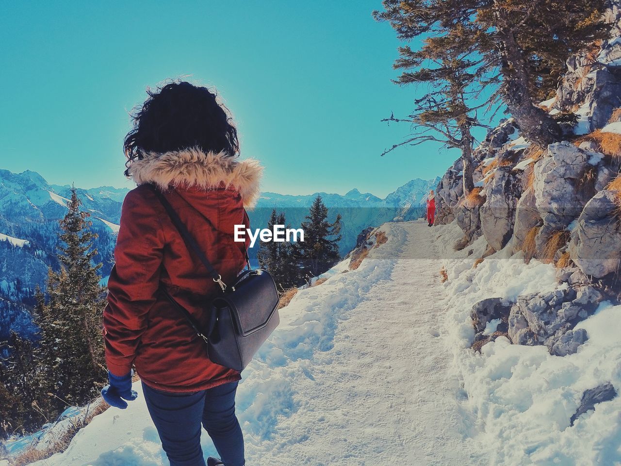 Rear view of woman standing on snow against sky