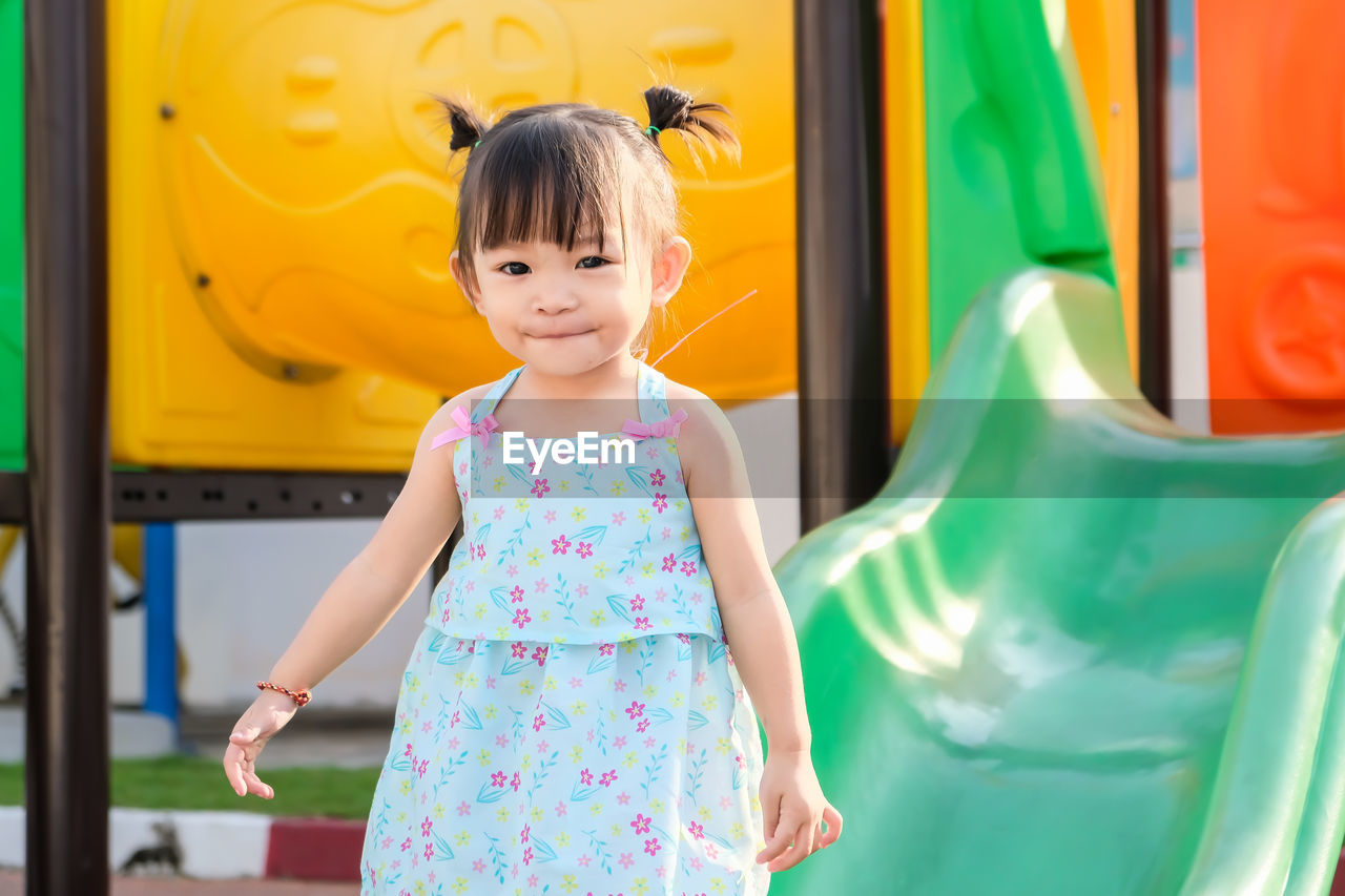 Portrait of cute baby girl standing at park