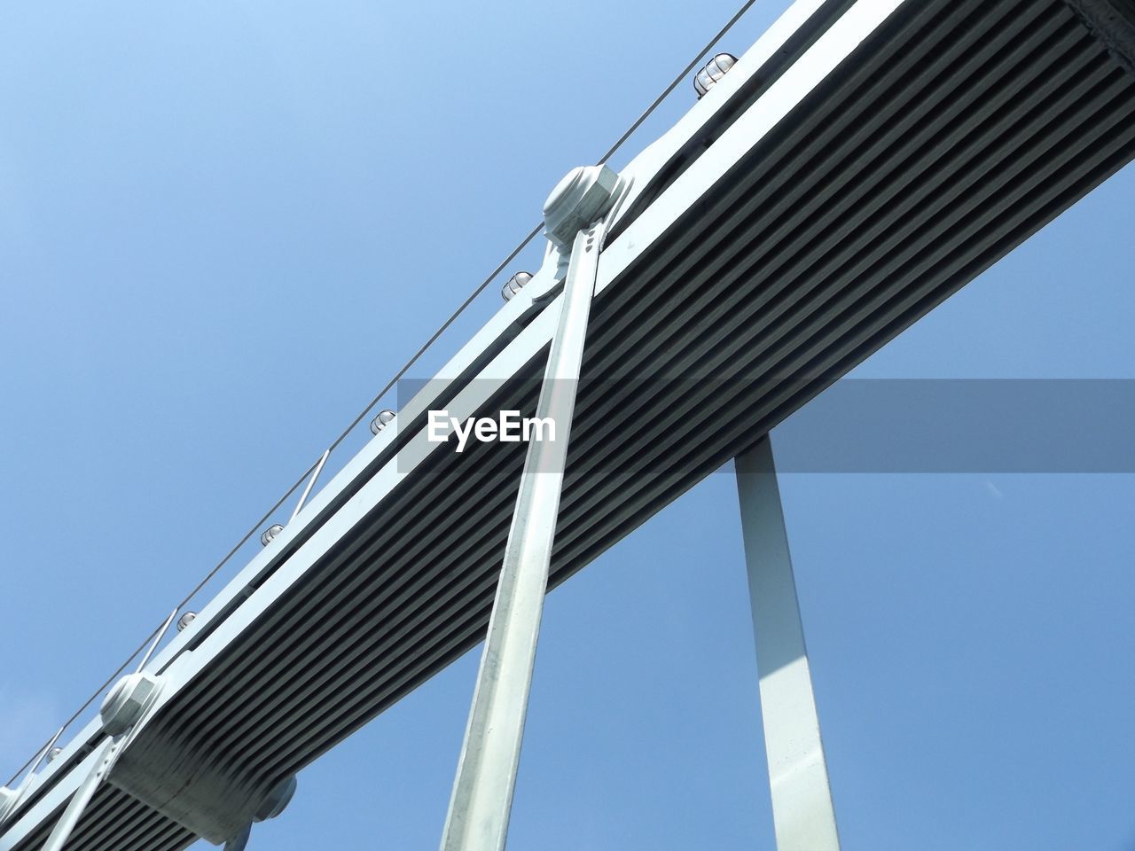 Low angle view of bridge against clear blue sky