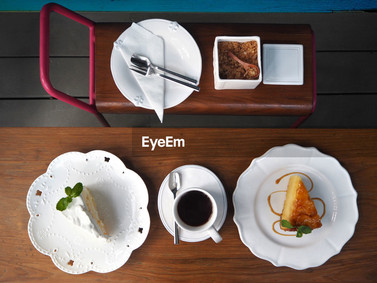 Directly above shot of cakes in plate by coffee cup on table in hotel