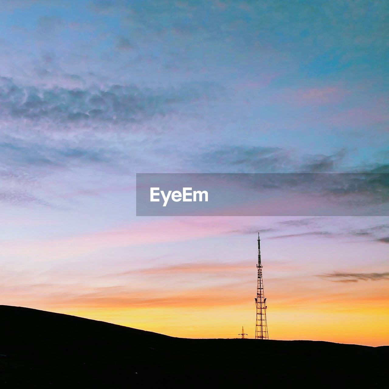 Electricity pylon against sky during sunset