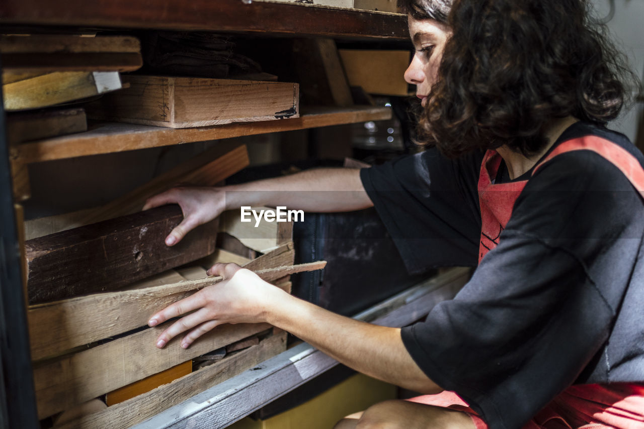 Woman luthier making guitars in her musical instrument workshop