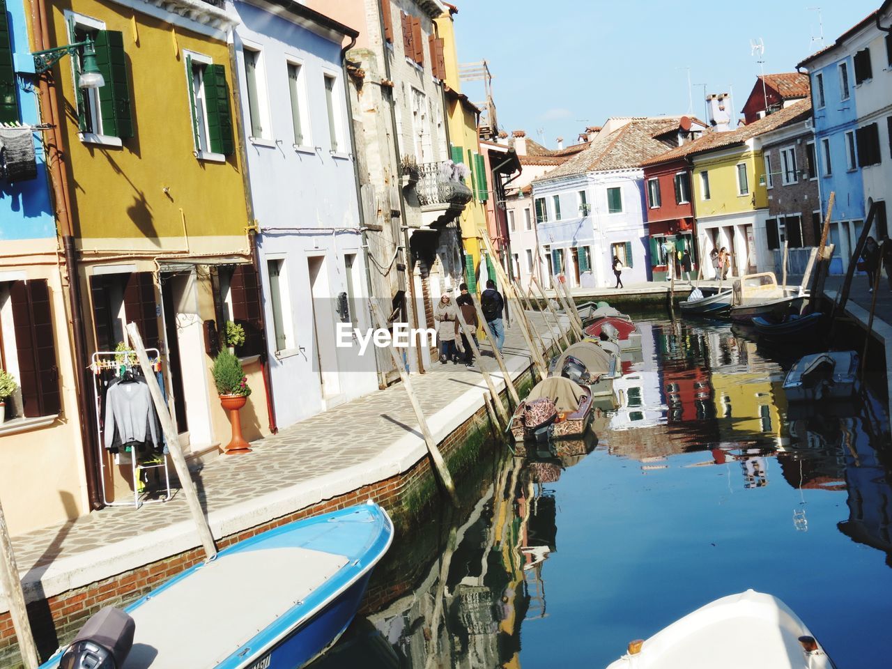 Boats moored on houses by water