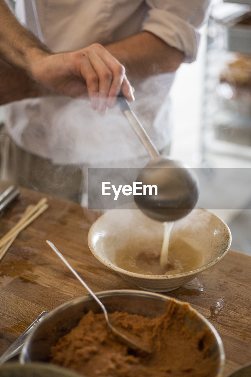 Midsection of man preparing food at table